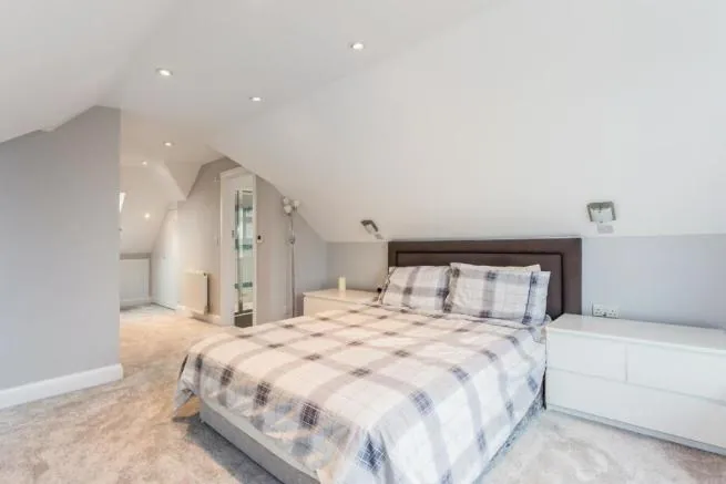 Loft bedroom with sloping ceilings and French doors