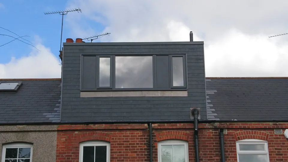 Slate-clad rear dormer with a wide window on a terraced Essex home