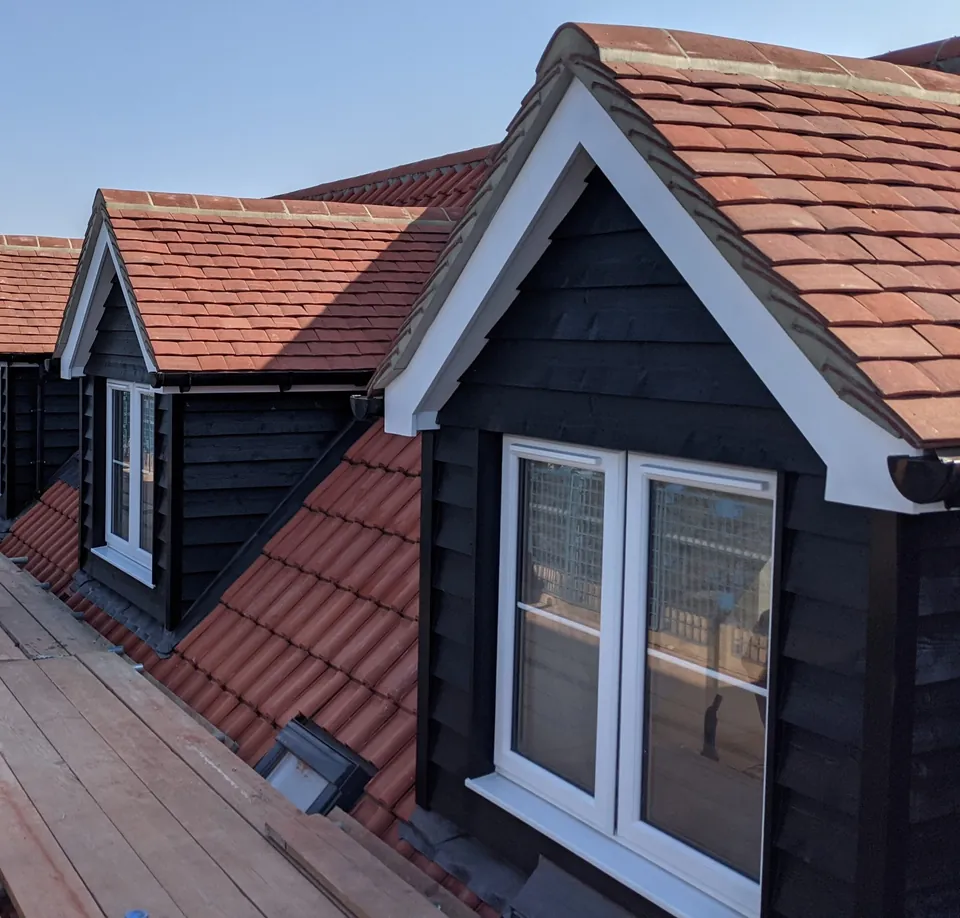 Gabled dormer windows clad in black timber with red clay roof tiles on a Brentwood Lofts loft conversion