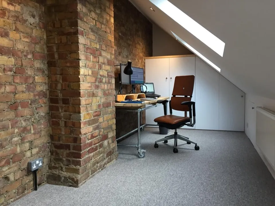 Loft office with exposed brick chimney breast and roof window