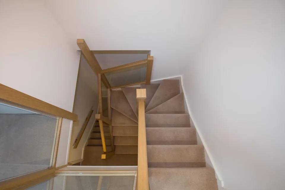 Oak and glass staircase leading up to a converted loft