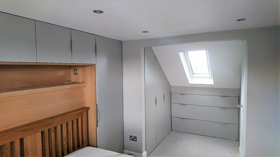 Fitted wardrobes built around a sloping roof with a roof window